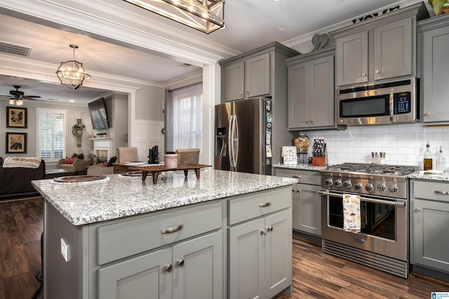 kitchen with a wealth of natural light, crown molding, and stainless steel appliances