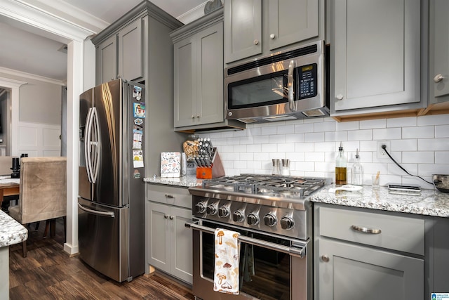 kitchen featuring dark hardwood / wood-style floors, gray cabinets, light stone counters, and stainless steel appliances