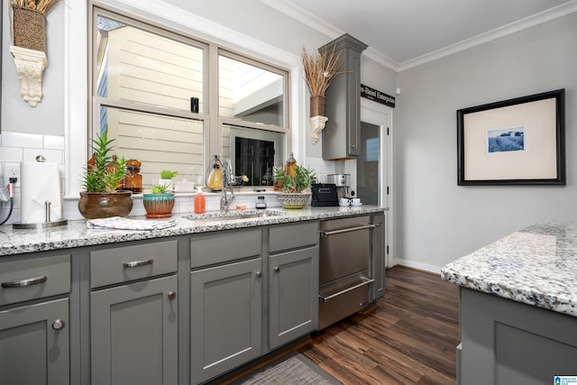 kitchen with gray cabinetry, sink, light stone counters, dark hardwood / wood-style floors, and ornamental molding