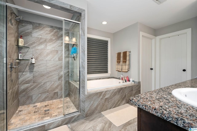 bathroom with vanity and separate shower and tub