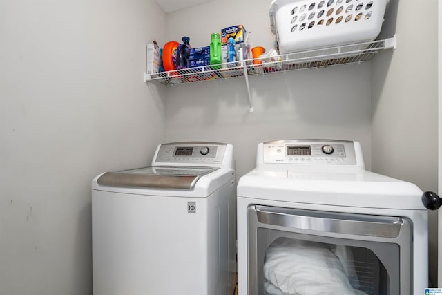 clothes washing area with separate washer and dryer