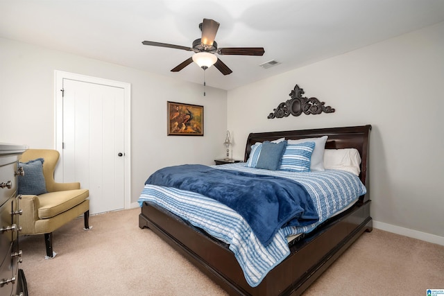 bedroom featuring ceiling fan, light carpet, and a closet