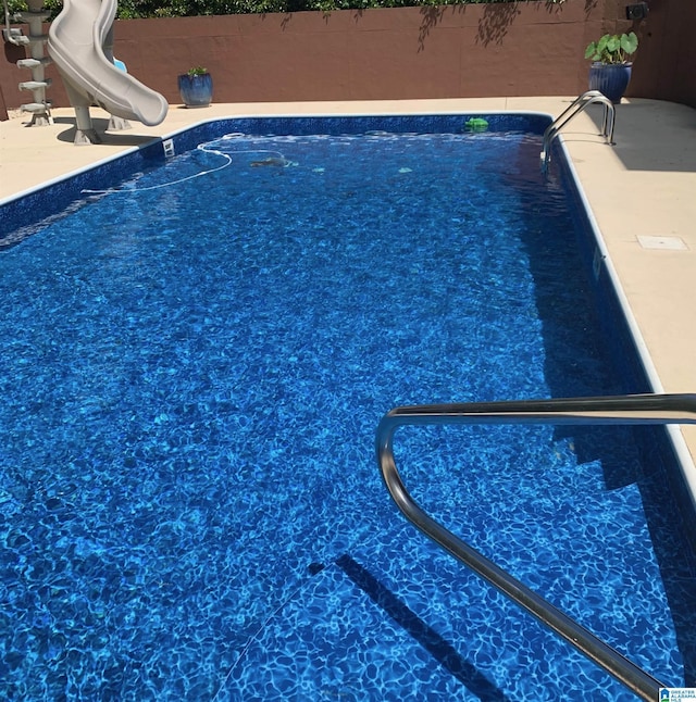 view of swimming pool with a water slide