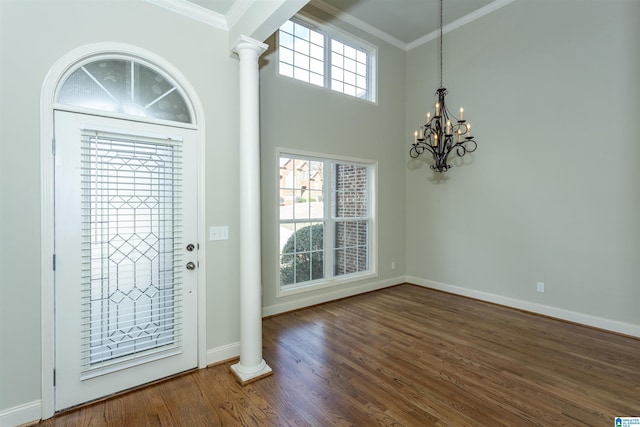 entrance foyer featuring dark hardwood / wood-style flooring, decorative columns, and a healthy amount of sunlight