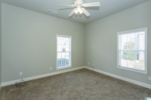 carpeted spare room featuring ceiling fan and a healthy amount of sunlight