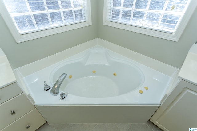 bathroom with tile patterned floors, plenty of natural light, and a tub