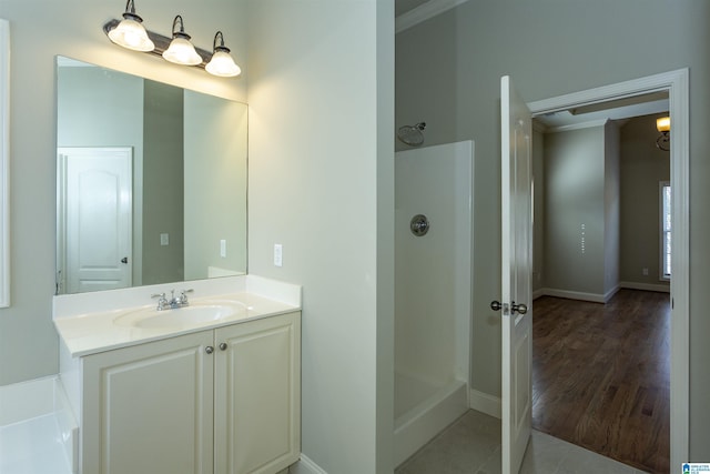 bathroom featuring a shower, vanity, ornamental molding, and hardwood / wood-style flooring