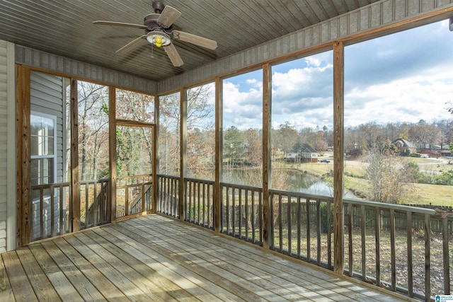 unfurnished sunroom with ceiling fan, a healthy amount of sunlight, a water view, and wooden ceiling