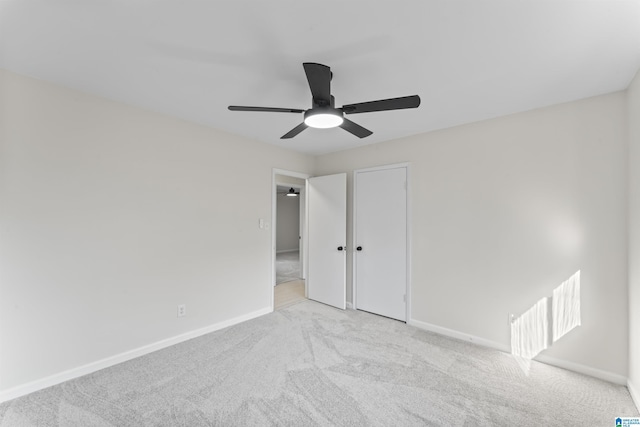 unfurnished bedroom featuring a closet, light colored carpet, and ceiling fan