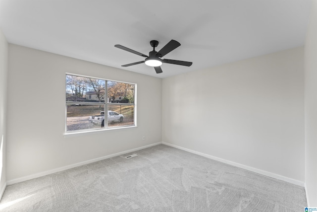 carpeted spare room featuring ceiling fan