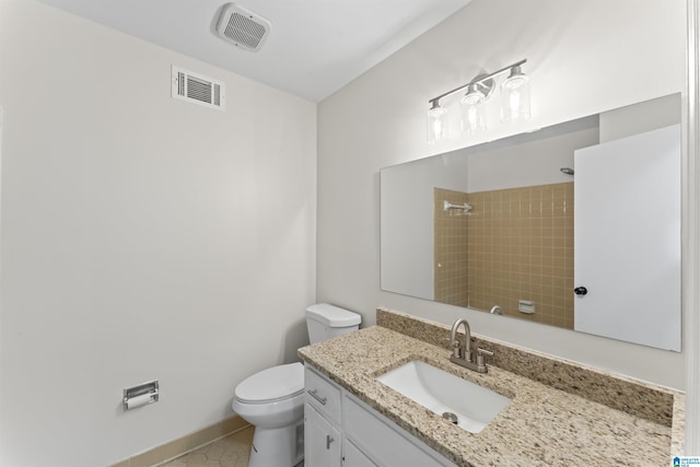 bathroom featuring tiled shower, tile patterned flooring, vanity, and toilet