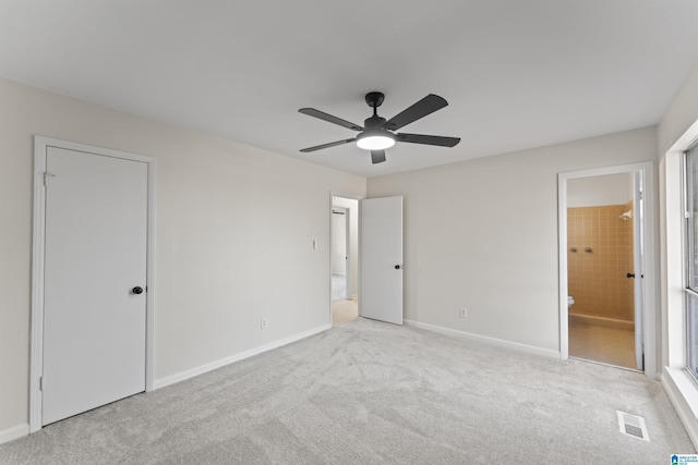 unfurnished bedroom with ensuite bathroom, ceiling fan, and light colored carpet