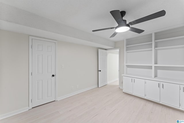 interior space featuring ceiling fan, light hardwood / wood-style floors, and a textured ceiling