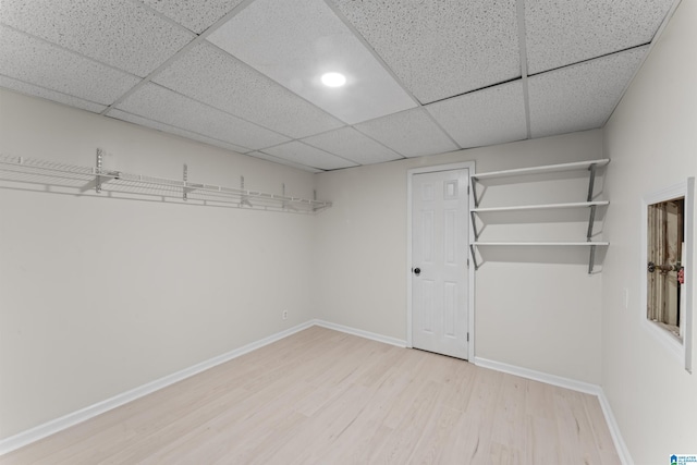 interior space featuring a paneled ceiling and light hardwood / wood-style flooring