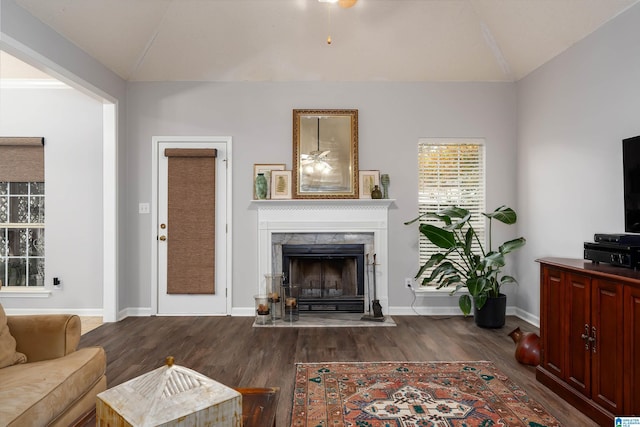 living room with dark hardwood / wood-style floors, a high end fireplace, and vaulted ceiling