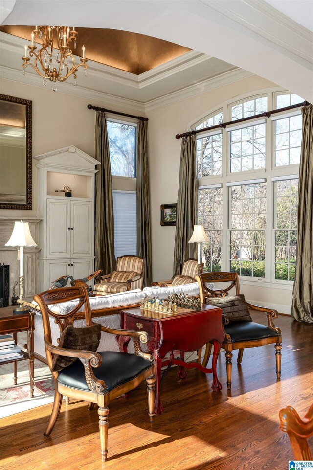 interior space featuring an inviting chandelier, wood-type flooring, and ornamental molding