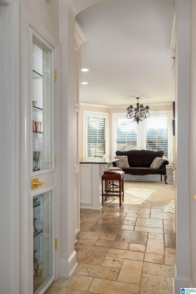 hallway featuring crown molding and a chandelier