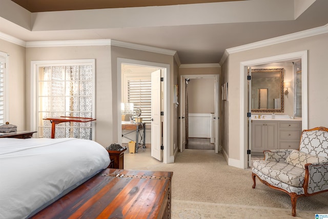 carpeted bedroom featuring connected bathroom, ornamental molding, and a raised ceiling