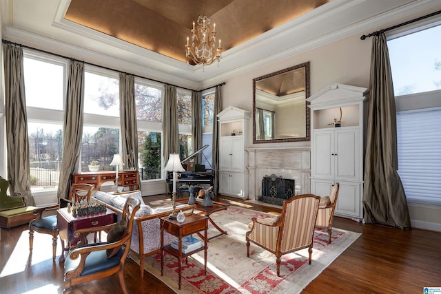 living area featuring crown molding, dark hardwood / wood-style floors, a raised ceiling, and a chandelier