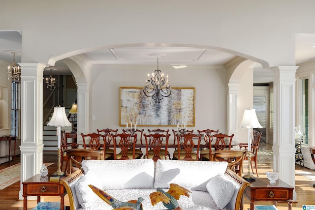 dining area featuring ornamental molding, a chandelier, hardwood / wood-style floors, and decorative columns