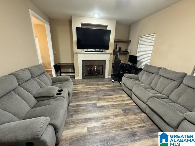 living room featuring a tile fireplace and wood-type flooring