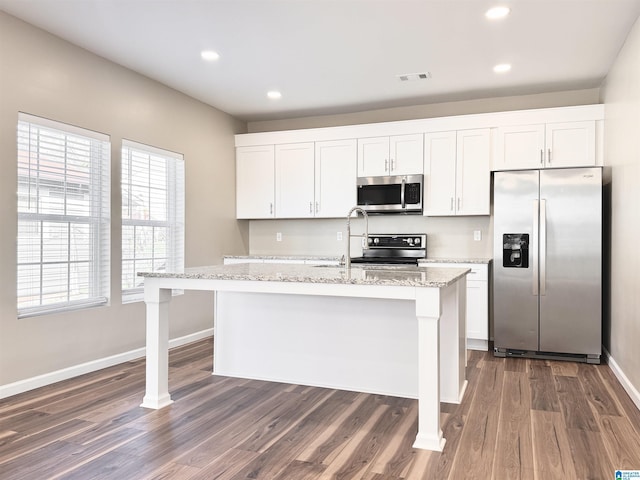 kitchen with white cabinetry, a kitchen island with sink, dark hardwood / wood-style flooring, and stainless steel appliances