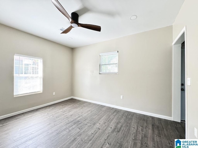 empty room featuring dark hardwood / wood-style floors, a healthy amount of sunlight, and ceiling fan