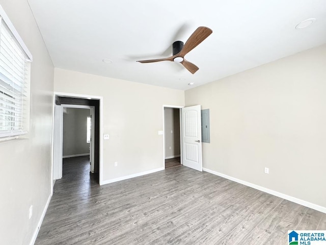 interior space with electric panel, ceiling fan, and hardwood / wood-style flooring