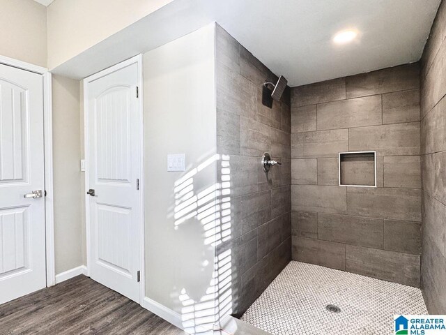 bathroom featuring a tile shower and hardwood / wood-style floors