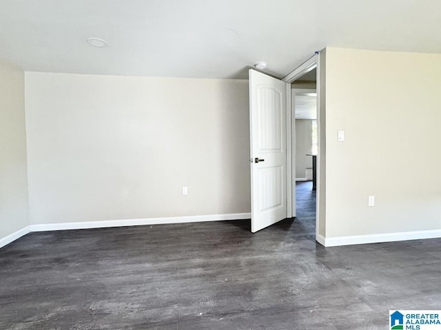 spare room with dark wood-type flooring