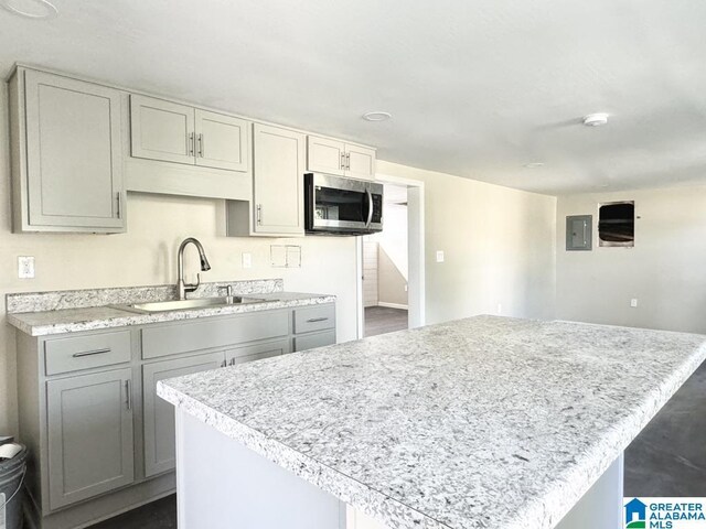 kitchen with a center island, gray cabinets, and sink