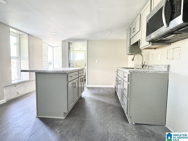 kitchen with gray cabinetry, a center island, dark hardwood / wood-style flooring, and sink