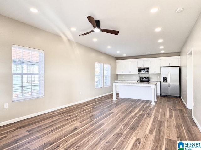 kitchen featuring plenty of natural light, wood-type flooring, white cabinetry, and appliances with stainless steel finishes