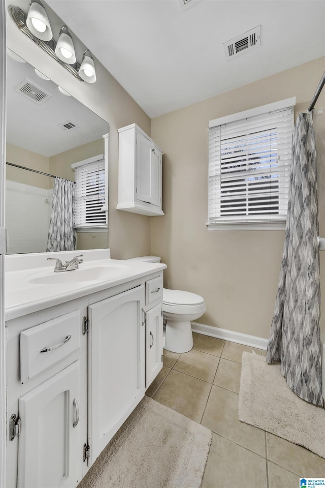 bathroom with toilet, vanity, and tile patterned floors