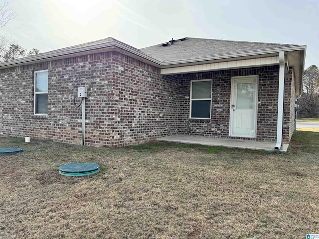 rear view of house featuring a patio area and a yard