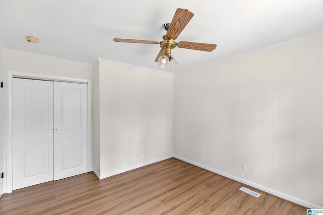 unfurnished bedroom with a closet, ceiling fan, light hardwood / wood-style flooring, and crown molding