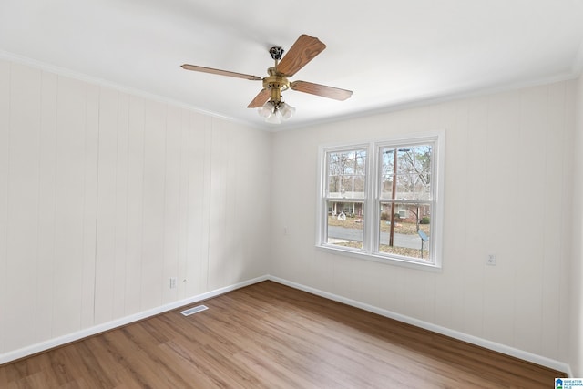 unfurnished room featuring ceiling fan, light hardwood / wood-style floors, and ornamental molding