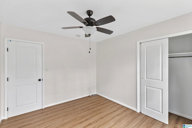 unfurnished bedroom featuring ceiling fan, a closet, and light wood-type flooring