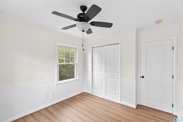 unfurnished bedroom featuring a closet, ceiling fan, light hardwood / wood-style flooring, and ornamental molding