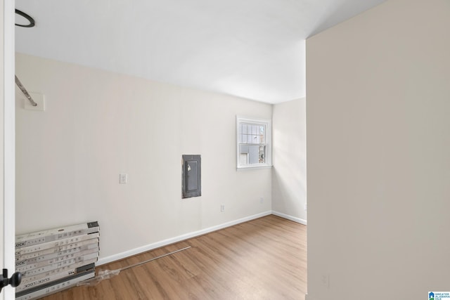 spare room with wood-type flooring and electric panel