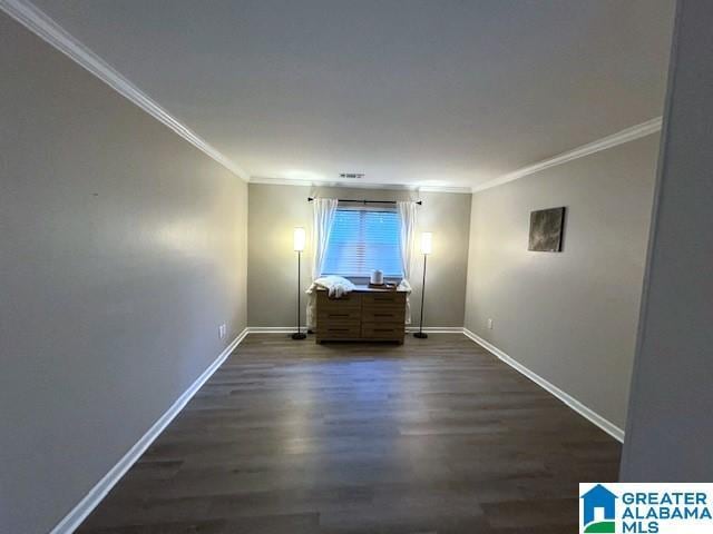 empty room featuring ornamental molding and dark wood-type flooring