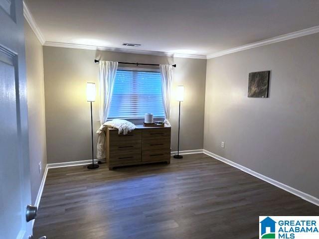 unfurnished bedroom featuring dark hardwood / wood-style floors and ornamental molding