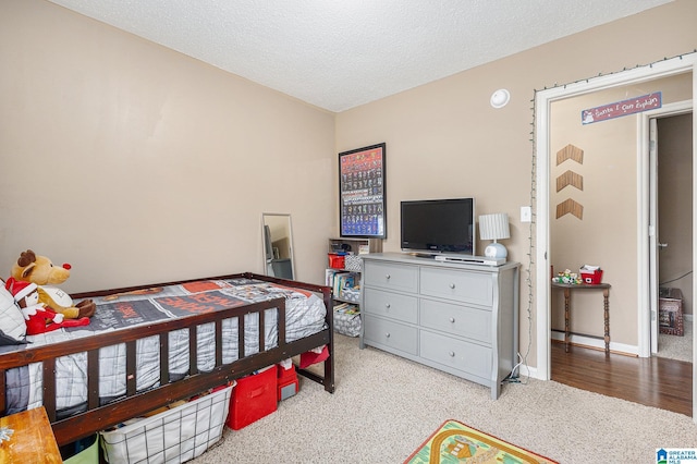 bedroom featuring light colored carpet and a textured ceiling