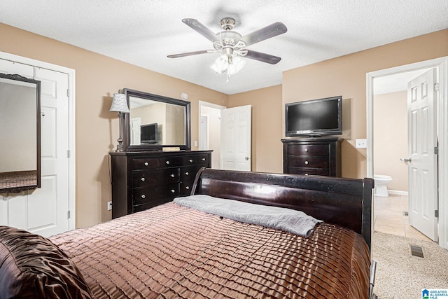 tiled bedroom featuring ceiling fan, a textured ceiling, and connected bathroom