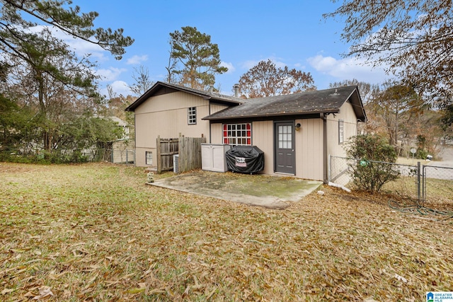 back of property with a yard and a patio