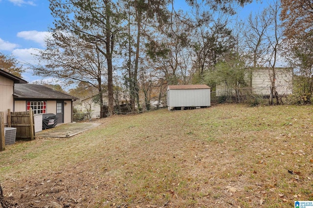 view of yard with a storage unit, central air condition unit, and a patio