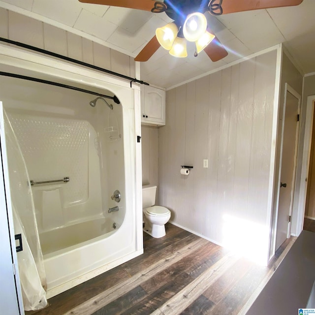 bathroom featuring crown molding, toilet, wooden walls, shower / bathtub combination, and hardwood / wood-style flooring