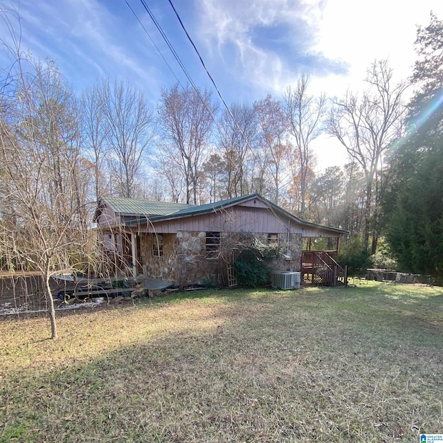 view of side of property featuring a lawn and cooling unit