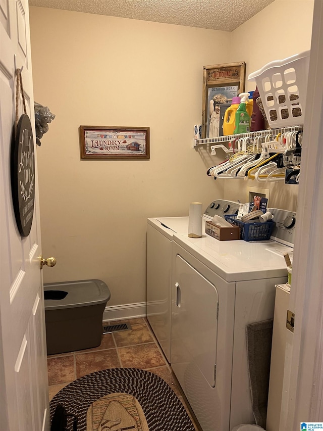 clothes washing area featuring washer and dryer and a textured ceiling