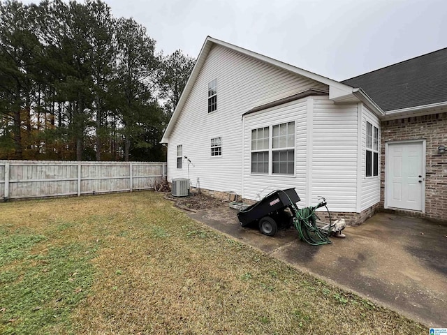 rear view of house with a yard and central AC unit